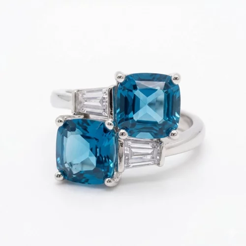 Eleganter Ring aus 925er Sterlingsilber besetzt mit zwei quadratischen blauen Zirkonia-Steinen in Topas-Optik und Baguette-Schliff Akzenten.